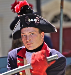 A close up photo of the face and upper body of a reenactor -- a man dressed as a soldier from the Civil War era.